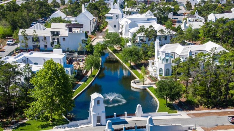 White stucco homes and palm trees along a quiet street in Alys Beach, Florida